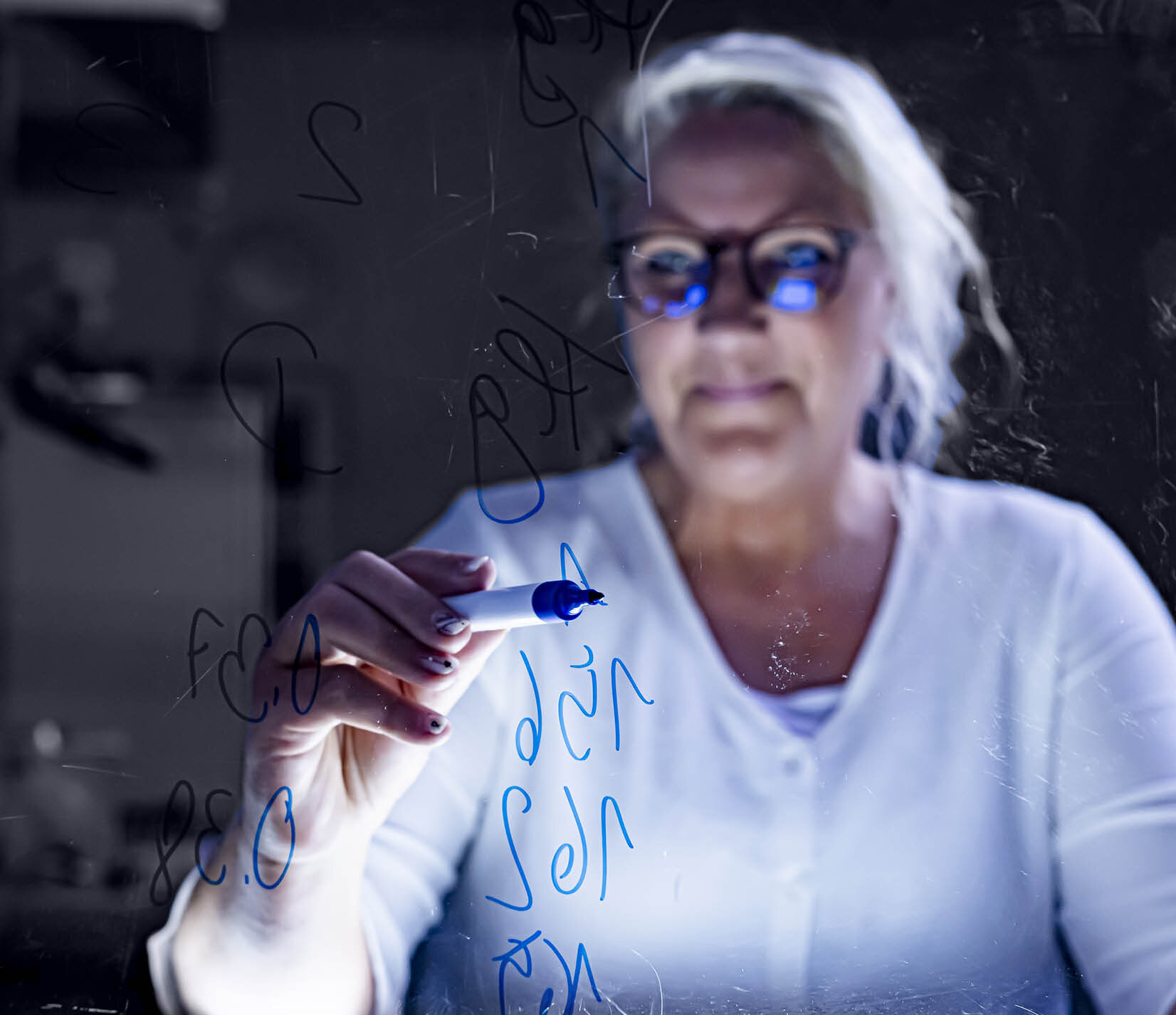 Frau schreibt Text auf eine Glasboard| Sandler Group