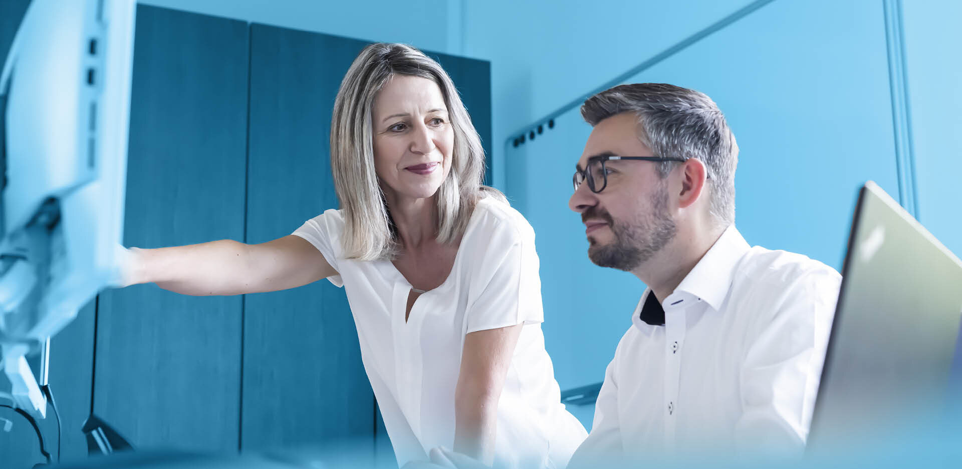 Zwei Mitarbeiter aus dem Bereich Personal und Finanzen am Computer | Sandler Group
