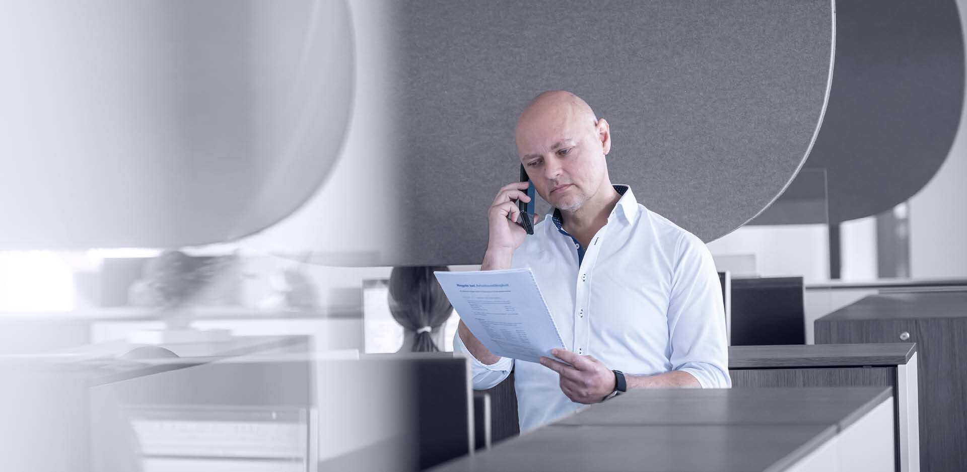 Mitarbeiter im Telefongespräch mit Zettel in der Hand | Sandler Group