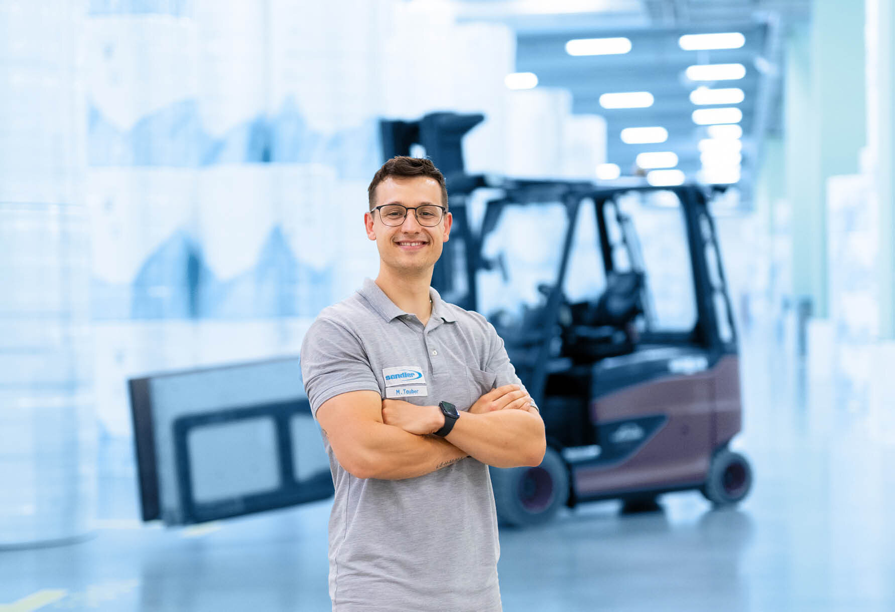 Mitarbeiter Max Taubner mit Gabelstapler im Hintergrund | Sandler Group